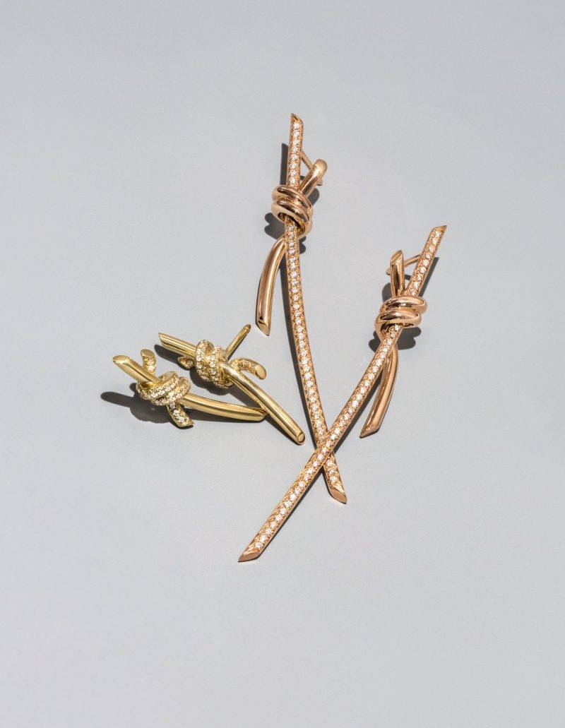 (由左至右) Tiffany Knot 系列 18k 黃金雙圈鑲鑽石耳環 $25,600 18k 玫瑰金雙圈鑲鑽石垂吊耳環 $47,700 （圖片來源： Tiffany & Co. ）